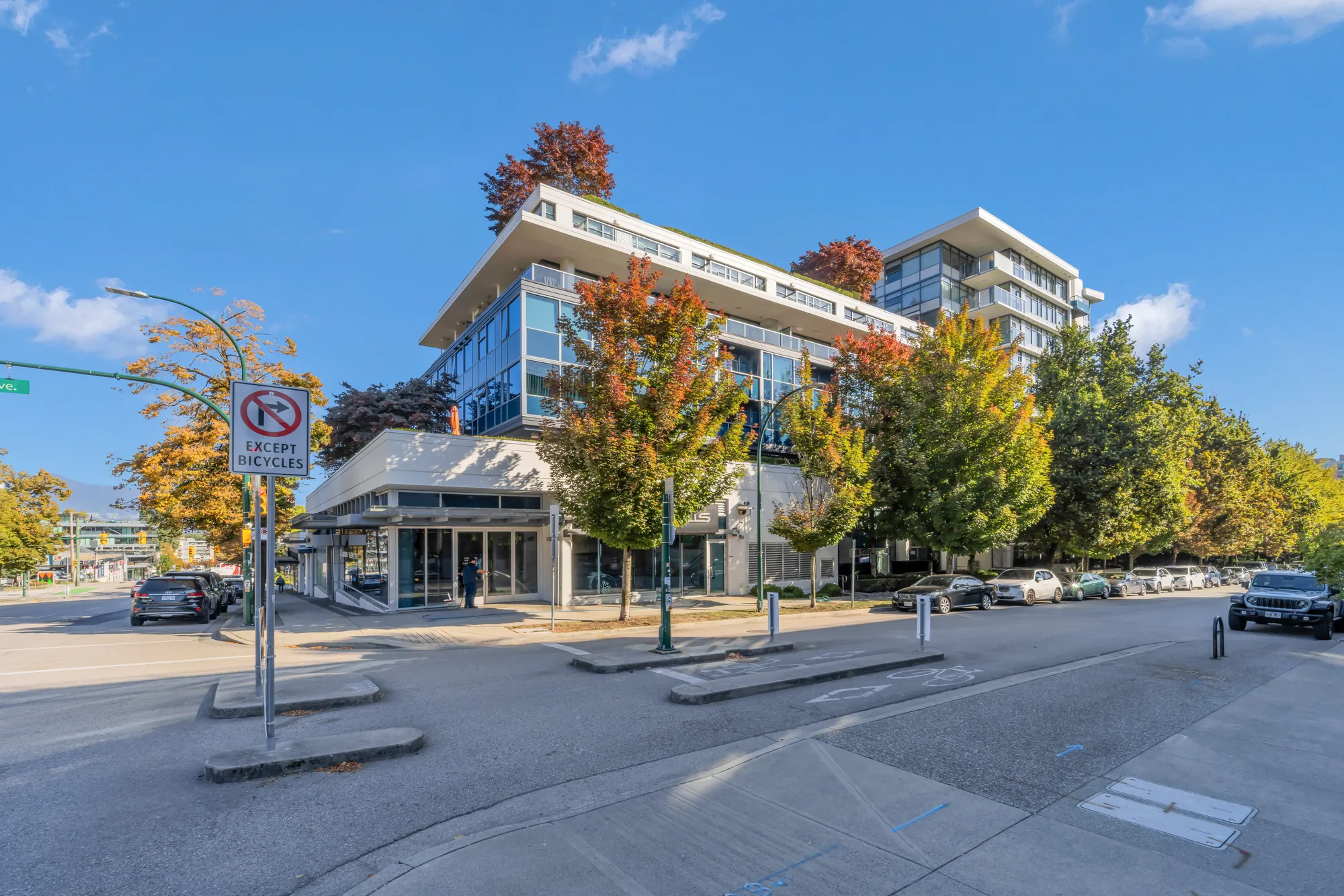 Kits360 from the corner of Burrard and 7th: the tower's glass balconies, the trees, the crosswalk